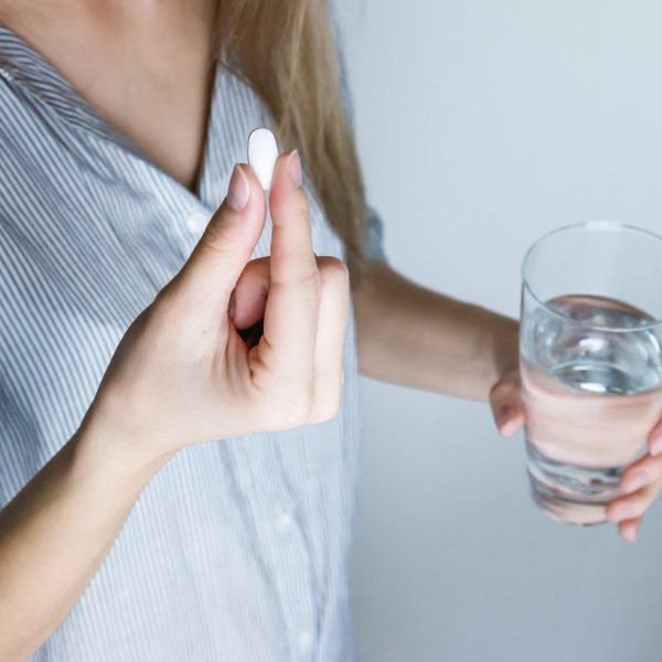 Woman taking medicine made by Gilead