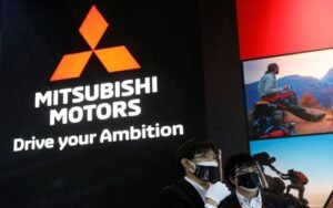 Staff members wearing protective masks and face shields, amid the coronavirus disease (COVID-19) pandemic, stand in front of the logo of Mitsubishi Motors at Tokyo Auto Salon 2022 at Makuhari Messe in Chiba, east of Tokyo, Japan January 14, 2022. REUTERS/Kim Kyung-Hoon