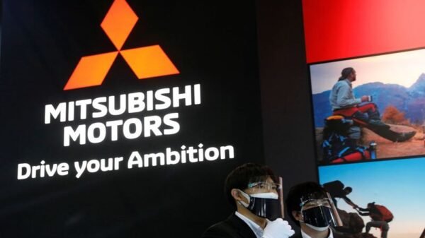 Staff members wearing protective masks and face shields, amid the coronavirus disease (COVID-19) pandemic, stand in front of the logo of Mitsubishi Motors at Tokyo Auto Salon 2022 at Makuhari Messe in Chiba, east of Tokyo, Japan January 14, 2022. REUTERS/Kim Kyung-Hoon