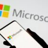 Smartphone is seen in front of Microsoft logo displayed in this illustration taken, July 26, 2021. REUTERS/Dado Ruvic/Illustration