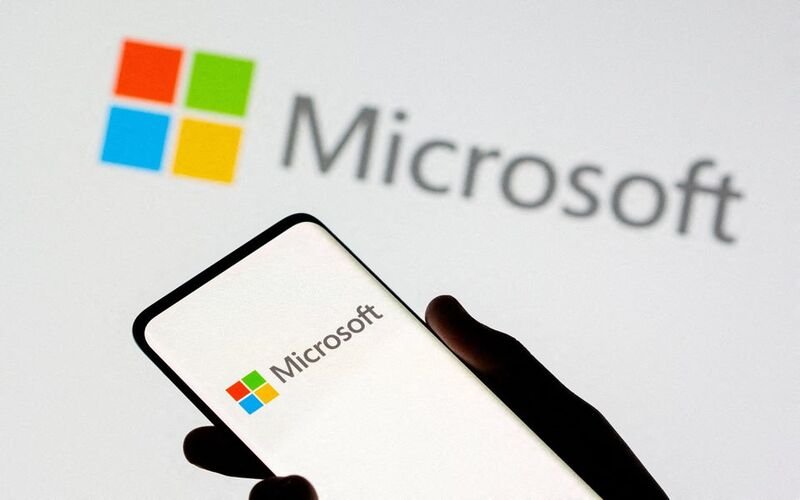 Smartphone is seen in front of Microsoft logo displayed in this illustration taken, July 26, 2021. REUTERS/Dado Ruvic/Illustration