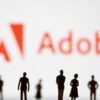 Figurines are seen in front of displayed Adobe logo in this illustration taken June 13, 2022. REUTERS/Dado Ruvic/Illustration