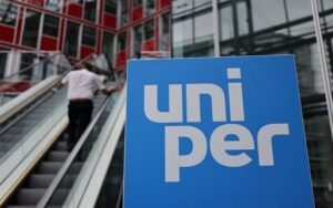 A person stands at escalators near the Uniper logo at the utility's firm headquarters in Duesseldorf, Germany, July 8, 2022. REUTERS/Wolfgang Rattay/File Photo