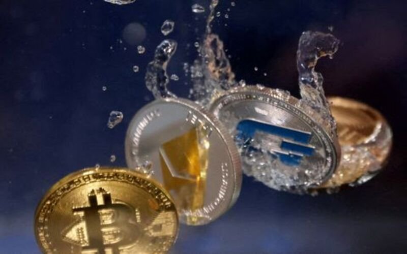 Representations of cryptocurrencies plunge into water in this illustration