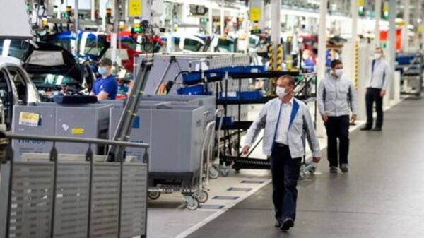 Staff wear protective masks at the Volkswagen assembly line in Wolfsburg, Germany