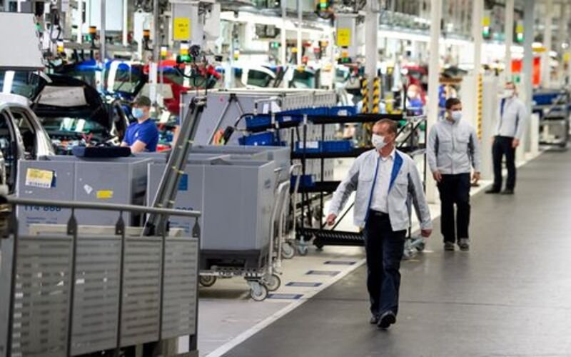 Staff wear protective masks at the Volkswagen assembly line in Wolfsburg, Germany