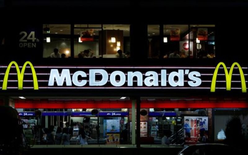 Customers are seen through the windows of a McDonald's store (top) in Tokyo, while others stand in line in front of cash registers, July 22, 2014. REUTERS/Yuya Shino/File Photo