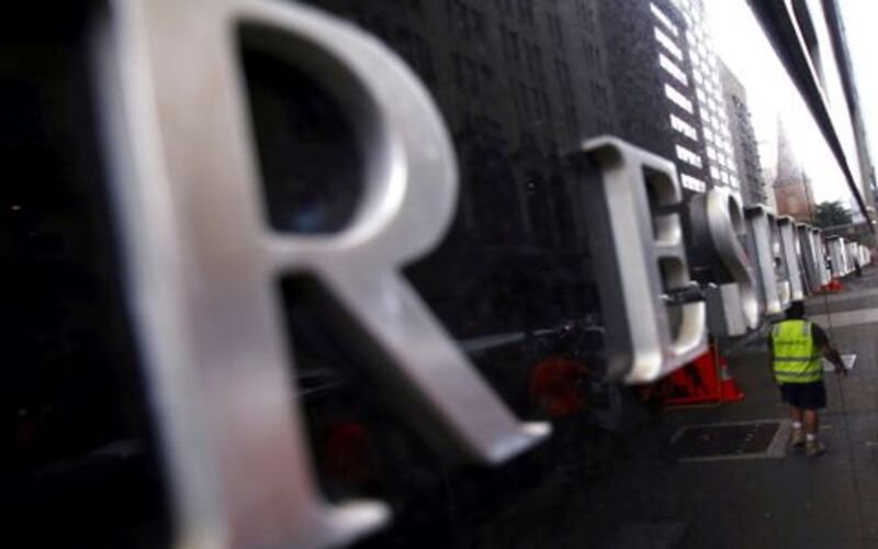 A worker is reflected in a wall of the Reserve Bank of Australia (RBA) head office in central Sydney, Australia,