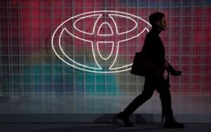 A man walks past a Toyota logo at the Tokyo Motor Show, in Tokyo, Japan October 24, 2019. REUTERS/Edgar Su/File Photo