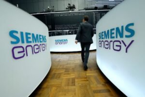 A trader walks next to Siemens Energy AG logos during Siemens Energy's initial public offering (IPO) at the Frankfurt Stock Exchange in Frankfurt, Germany, September 28, 2020. REUTERS/Ralph Orlowski/ File Photo
