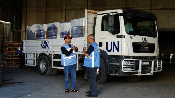 Workers stand by a United Nations vehicle, while sorting aid to be distributed to Palestinians, as the conflict between Israel and Palestinian Islamist group Hamas continues, at a United Nations-run facility, in Khan Younis in the southern Gaza Strip, October 26, 2023. REUTERS/Ibraheem Abu Mustafa