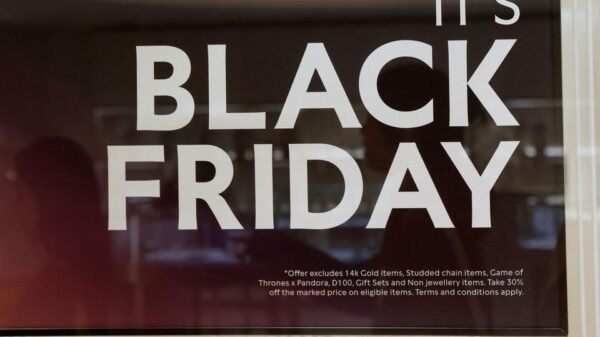 Shoppers are reflected in a Black Friday sign outside a shop in Singapore November 22, 2023. REUTERS/Edgar Su