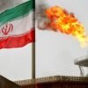 A gas flare on an oil production platform is seen alongside an Iranian flag in the Gulf July 25, 2005. REUTERS/Raheb Homavandi