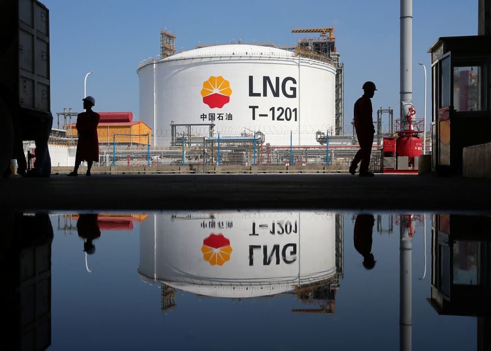 A liquified natural gas(LNG) storage tank and workers are reflected in a puddle at PetroChina's receiving terminal at Rudong port in Nantong, Jiangsu province, China September 4, 2018. REUTERS/Stringer/File Photo