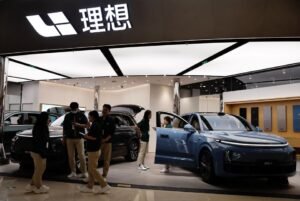Staff members stand at the booth of Chinese electric vehicle (EV) maker Li Auto, at a shopping mall in Beijing, China November 3, 2023. REUTERS/Tingshu Wang/File Photo