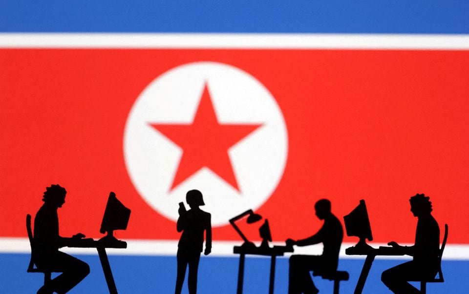 Miniatures of people with computers are seen in front of North Korea flag in this illustration taken July 19, 2023. REUTERS/Dado Ruvic/Illustration/File Photo