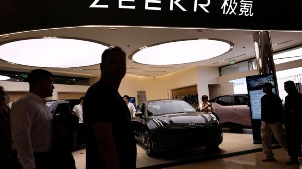 People walk past a booth of Zeekr, Chinese automaker Geely's premium electric vehicle (EV) brand, at a shopping mall in Beijing, China November 3, 2023. REUTERS/Tingshu Wang/File Photo