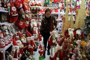 A vendor sorts products at a booth selling Christmas decorations at a mall in Beijing, China December 14, 2023. REUTERS/Tingshu Wang/File Photo