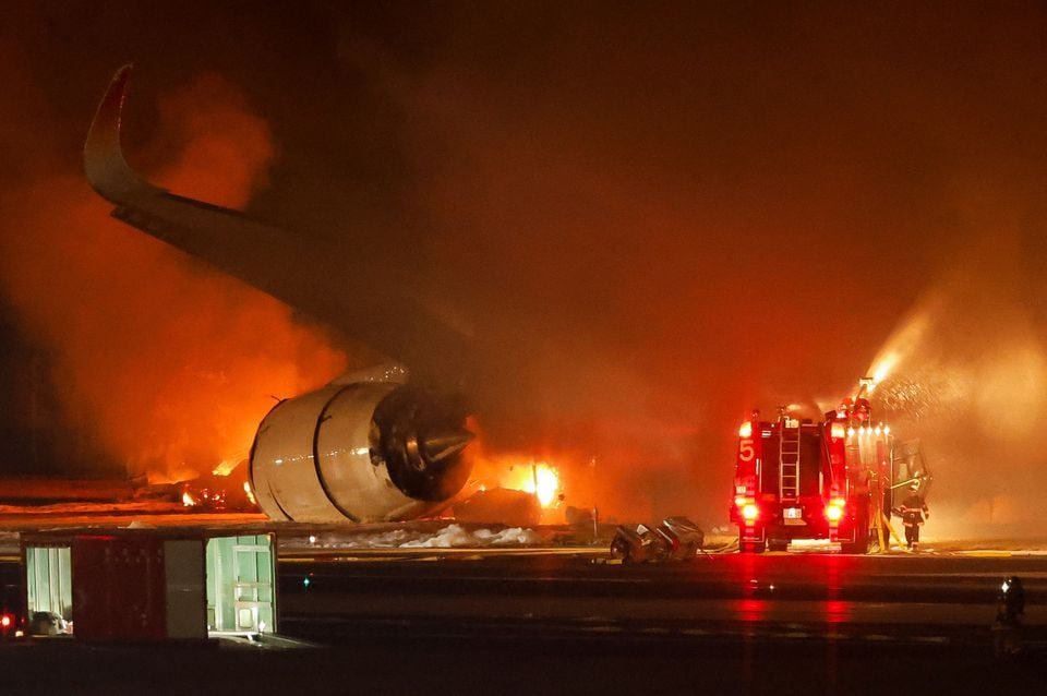 Firefighters work at Haneda International Airport after Japan Airlines' A350 airplane caught on fire, in Tokyo, Japan January 2, 2024. REUTERS/Issei Kato