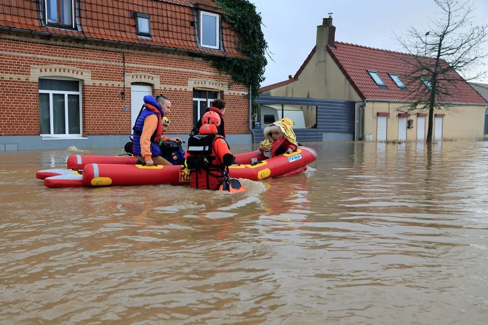 Members of French Civil Security rescue team evacuate local residents by boat as the Aa River overflows in Arques near Saint-Omer, after heavy rain caused flooding in northern France, January 3, 2024. REUTERS/Pascal Rossignol